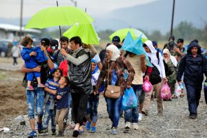 On 10 September, children, women and men who have fled their homes amid the ongoing refugee and migrant crisis walk along a rocky path, on a rainy day near the town of Gevgelija, on the border with Greece. Many are using umbrellas, hooded articles of clothing and other items in an attempt to stay dry. In late August 2015 in the former Yugoslav Republic of Macedonia, more than 52,000 people have been registered at the border by police near the town of Gevgelija, after entering from Greece, since June 2015. Since July 2015, the rate of refugees and migrants transiting through the country has increased to approximately 2,000 to 3000 people per day. Women and children now account for nearly one third of arrivals. An estimated 12 per cent of the women are pregnant. Many are escaping conflict and insecurity in their home countries of Afghanistan, Iraq, Pakistan and the Syrian Arab Republic. There are children of all ages traveling with their families. Some are unaccompanied minors aged 16?18 years who are traveling in groups with friends. They are arriving in the country from Greece, transiting to Serbia and further to Hungary, from where they generally aim to reach other countries in the European Union.