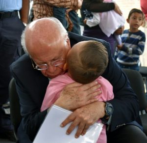 Secretario de Salud, José Narro, abraza a niña, en Querétaro. Foto de Secretaría de Salud